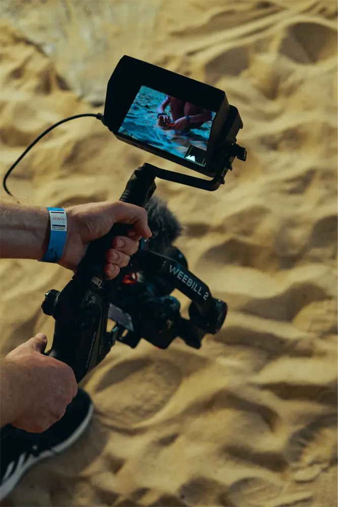 A camera shooting content with sand beneath it