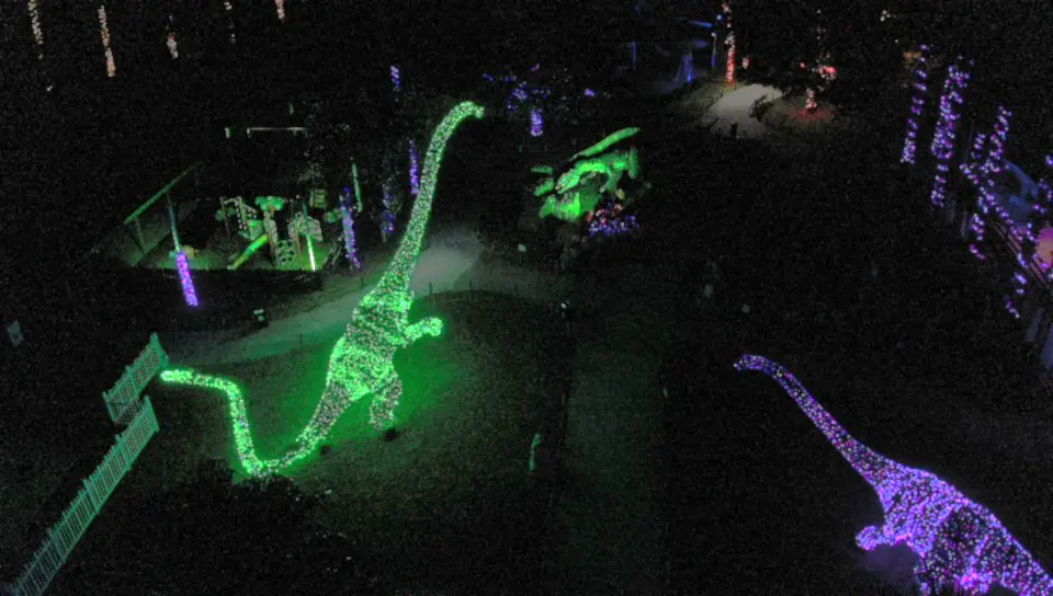 A drone photo of Dinosaur World decorated with holiday lights at night
