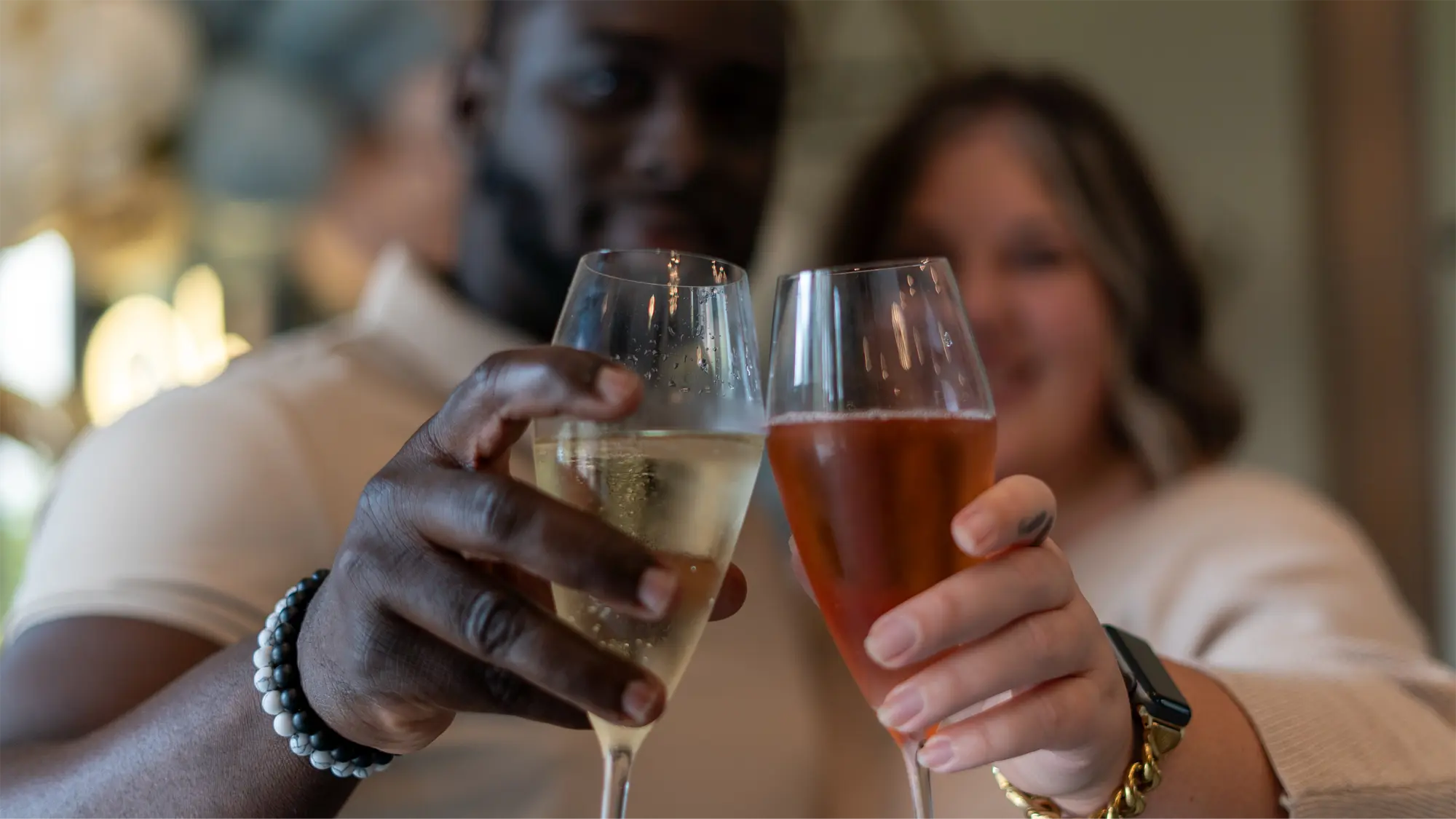 Two people holding champagne glasses together
