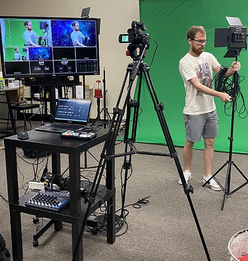 A man setting up livestreaming equiptment