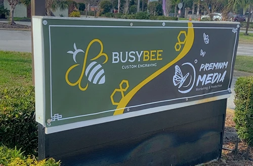 A sign outside of a business for Busy Bee and Premium Media